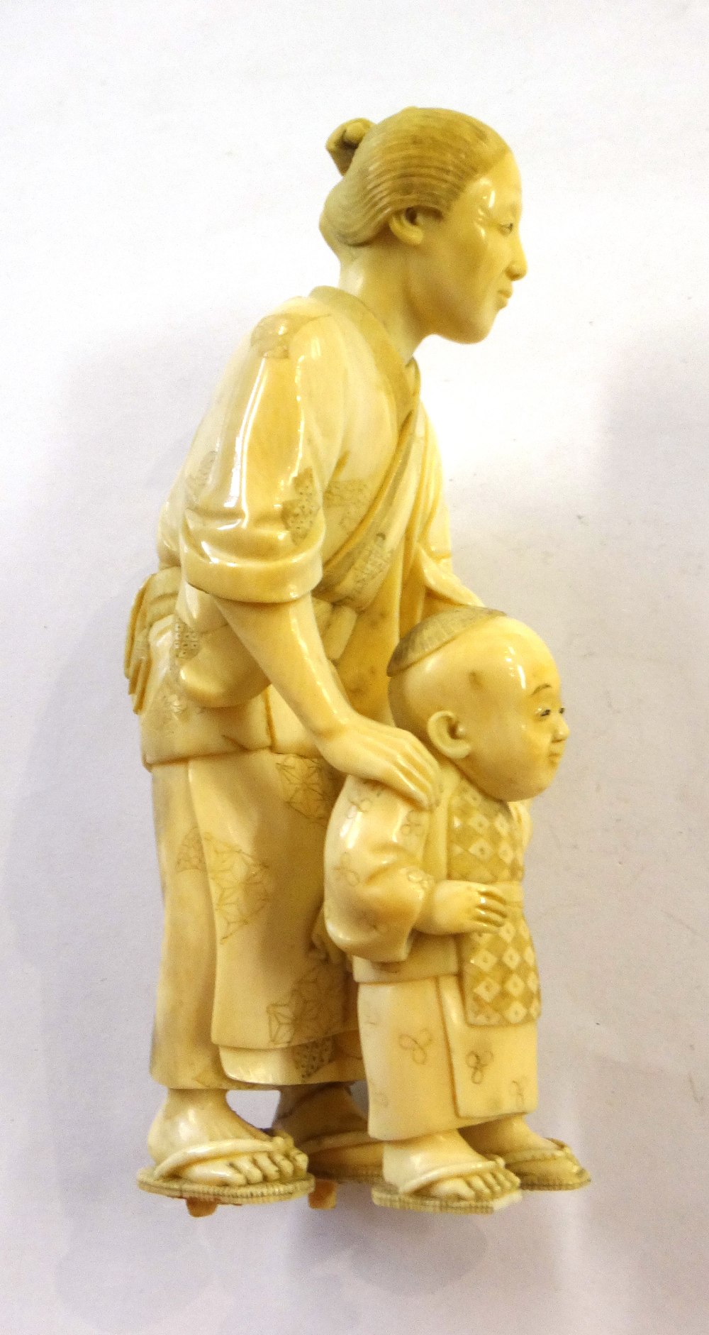 A Japanese ivory okimono of a woman helping a child to walk, Meiji period, - Image 5 of 12