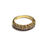 An 18ct gold and diamond set seven stone half hoop ring,