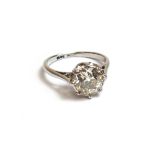 A white gold and platinum, diamond set single stone ring, mounted with a cushion shaped diamond,