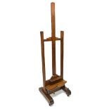 A 19th century oak artist's easel with wooden worm, on trestle supports, 55cm wide.