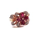 A 14ct gold, ruby and diamond set cluster ring, in a stylized flowerhead shaped design,