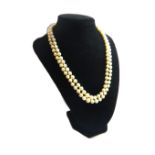 A two row necklace of cultured pearls, graduating in size to the front, on a silver snap clasp,