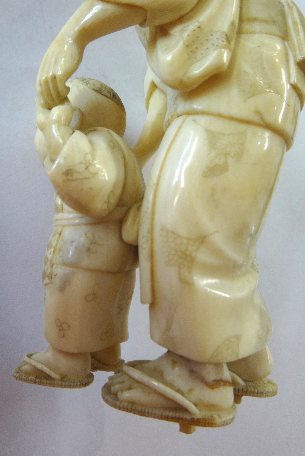 A Japanese ivory okimono of a woman helping a child to walk, Meiji period, - Image 10 of 12