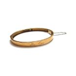 A gold and diamond set single stone oval hinged bangle,