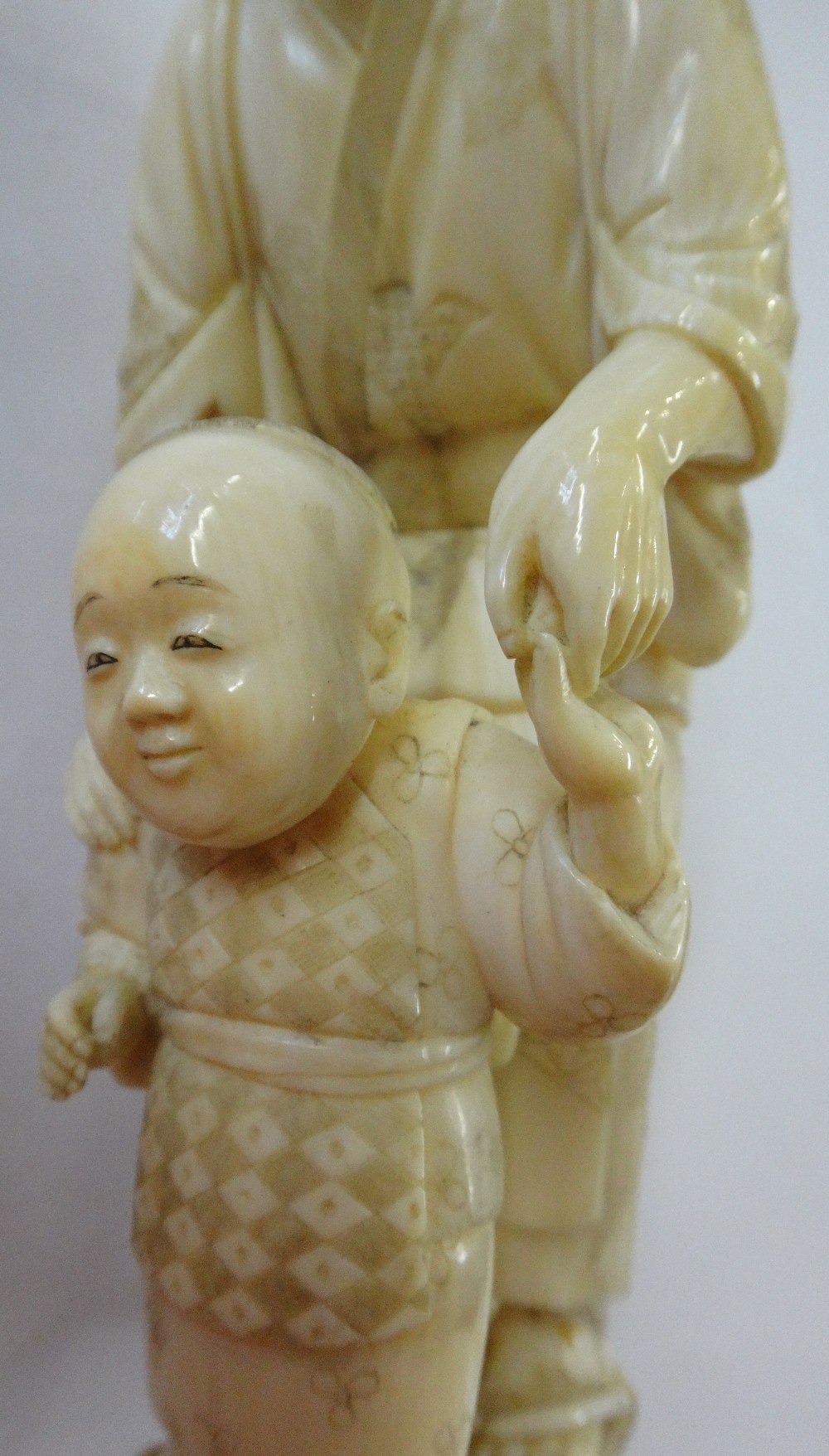 A Japanese ivory okimono of a woman helping a child to walk, Meiji period, - Image 7 of 12