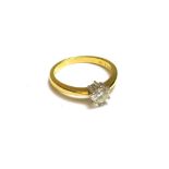 An 18ct gold and diamond set single stone ring, claw set with a circular cut diamond,