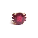 An 18ct gold and ruby set ring, claw set with the principal oval cut ruby at the centre,