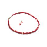 A single row necklace of coral beads, on a gold snap clasp,