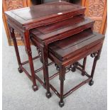 A nest of three Chinese hardwood occasional tables with carved frieze on turned supports,