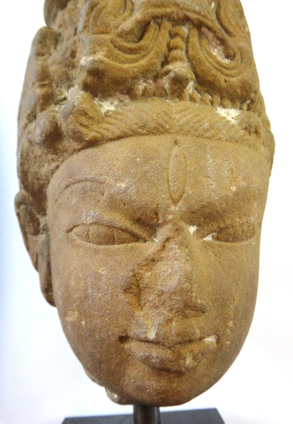 A sandstone head of a deity, Central India, circa 11th/12th century,wearing a tall headdress, (a. - Image 2 of 5