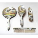 A ladies silver and enameled four piece dressing set, comprising; a hand mirror, a hairbrush,