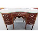 A 19th century inlaid mahogany kidney shaped writing desk with seven drawers about the knee on