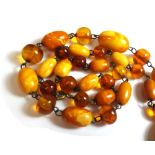 A single row necklace of graduated oval mottled butterscotch coloured amber beads,