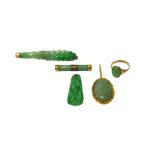 An Oriental gold mounted carved jade brooch, a jade brooch of baton form,