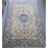 A Tabriz rug, Persian, the fawn field with an indigo medallion, spandrels, floral sprays,