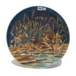 An Austrian pottery charger, early 20th century, relief moulded with wildfowl amongst bullrushes,