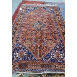 A Shiraz carpet, South Persian, the madder field with a central medallion, indigo spandrels,