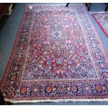 A Kashan rug, Persian, the madder field with an indigo pole medallion, floral sprays,