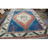 A Turkish carpet, the indigo field with a large ivory and madder medallion, plants to each corner,