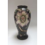 A Moorcroft pottery vase, circa 1998, decorated with passion flower against a dark green ground,