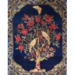 A Kerman mat, Persian, the indigo field with a flowering tree, a pair of birds, spandrels,