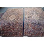 A pair of Kashan rugs, Persian, each with an indigo field and ivory medallion, matching spandrels,