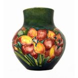 A Moorcroft pottery vase, mid-20th century, tube line decorated with lilies against a green ground,