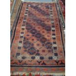 A Beluchistan rug, the banded field with hooked medallions, a leaf border, 186cm x 104cm.