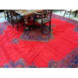 A Turkish carpet, the plain red field with a bold indigo red medallion, matching spandrels,