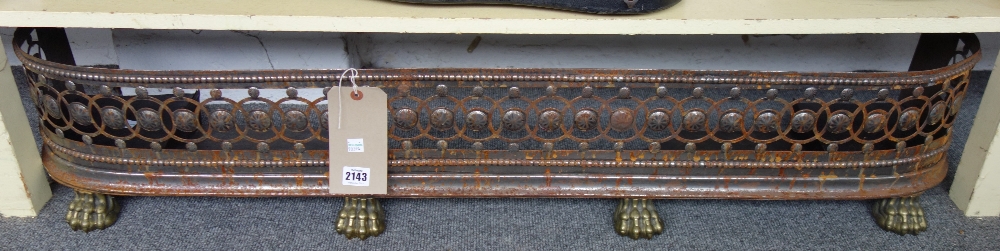 A Victorian steel and brass mounted fire curb with pierced frieze and four lions paw feet,
