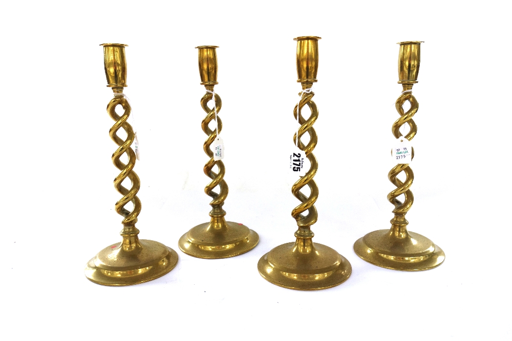 A set of four Victorian brass candlesticks, each with an open barley-twist stem on a circular foot,