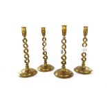 A set of four Victorian brass candlesticks, each with an open barley-twist stem on a circular foot,