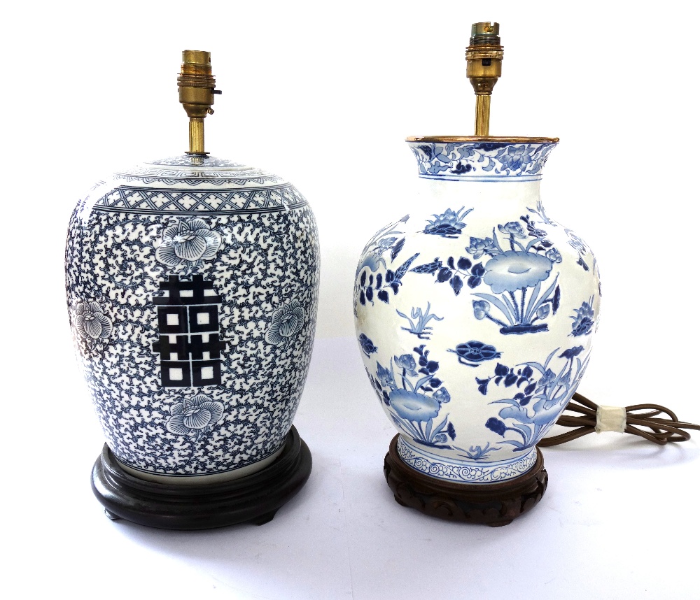 A set of four modern Chinese style pottery table lamps decorated with blue flowers against a white