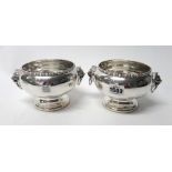 A pair of silver twin handled bowls, each of circular form having a decorated rim,