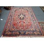 A Sarough rug, Persian, the madder field with a black medallion, matching spandrels,
