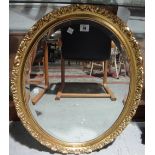 A gilt framed oval wall mirror.