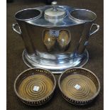 A silver plated two bottle wine cooler and a pair of silver plated bottle coasters.