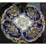 A Meissen porcelain plate decorated with gilt flowers on a blue ground.