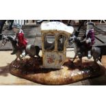 A 19th century Continental ceramic figure group depicting figures in a sedan chair, 31cm wide.