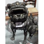 An Oriental bronze figure of a dog with a removable head.