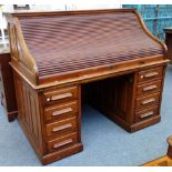An early 20th century walnut roll top desk with fitted interior on pair of pedestals, 154cm wide.