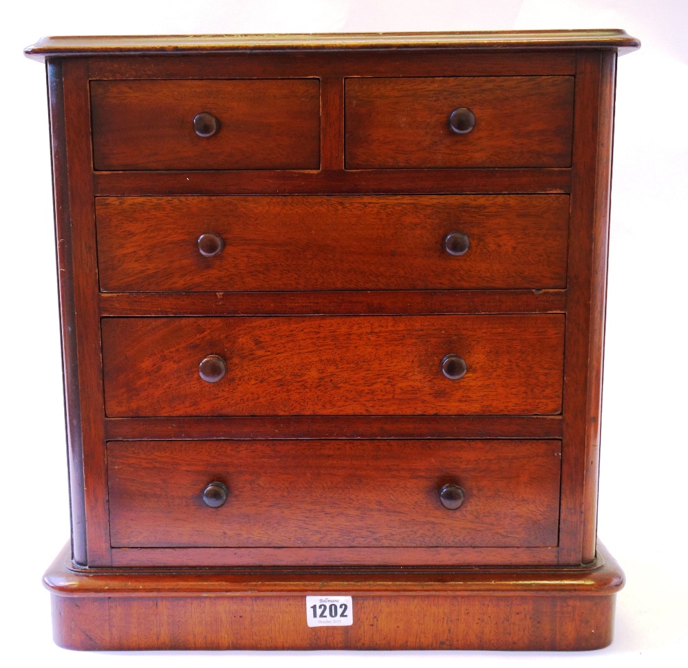 A mahogany miniature chest of two short and three long graduated drawers, on plinth base, 40cm wide.