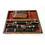 A three piece rosewood flute, early 20th century, cased,