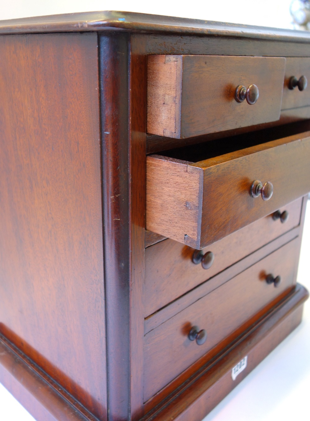 A mahogany miniature chest of two short and three long graduated drawers, on plinth base, 40cm wide. - Image 2 of 2