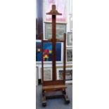 A 19th century oak artist's easel with wooden worm, on trestle supports, 55cm wide.