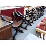 A matched set of six Italian walnut framed folding 'X' framed chairs with leather upholstery.