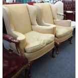 A pair of George I style wingback armchairs, on walnut cabriole supports.