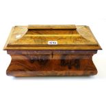 A Victorian figured walnut tea caddy of bloated sarcophagus form with twin lidded interior,
