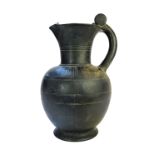 An Etruscan Buchero jug with incised banded decoration to the shoulders, 32cm high.