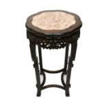 A late 19th century Chinese Hongmu jardinere stand with shaped inset marble top on four carved
